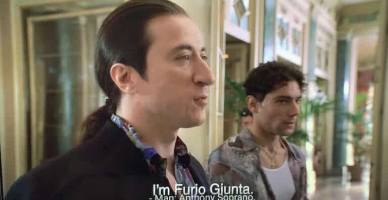 Furio Giunta is greeting Tony, Paulie, and Christopher at the hotel in Italy.